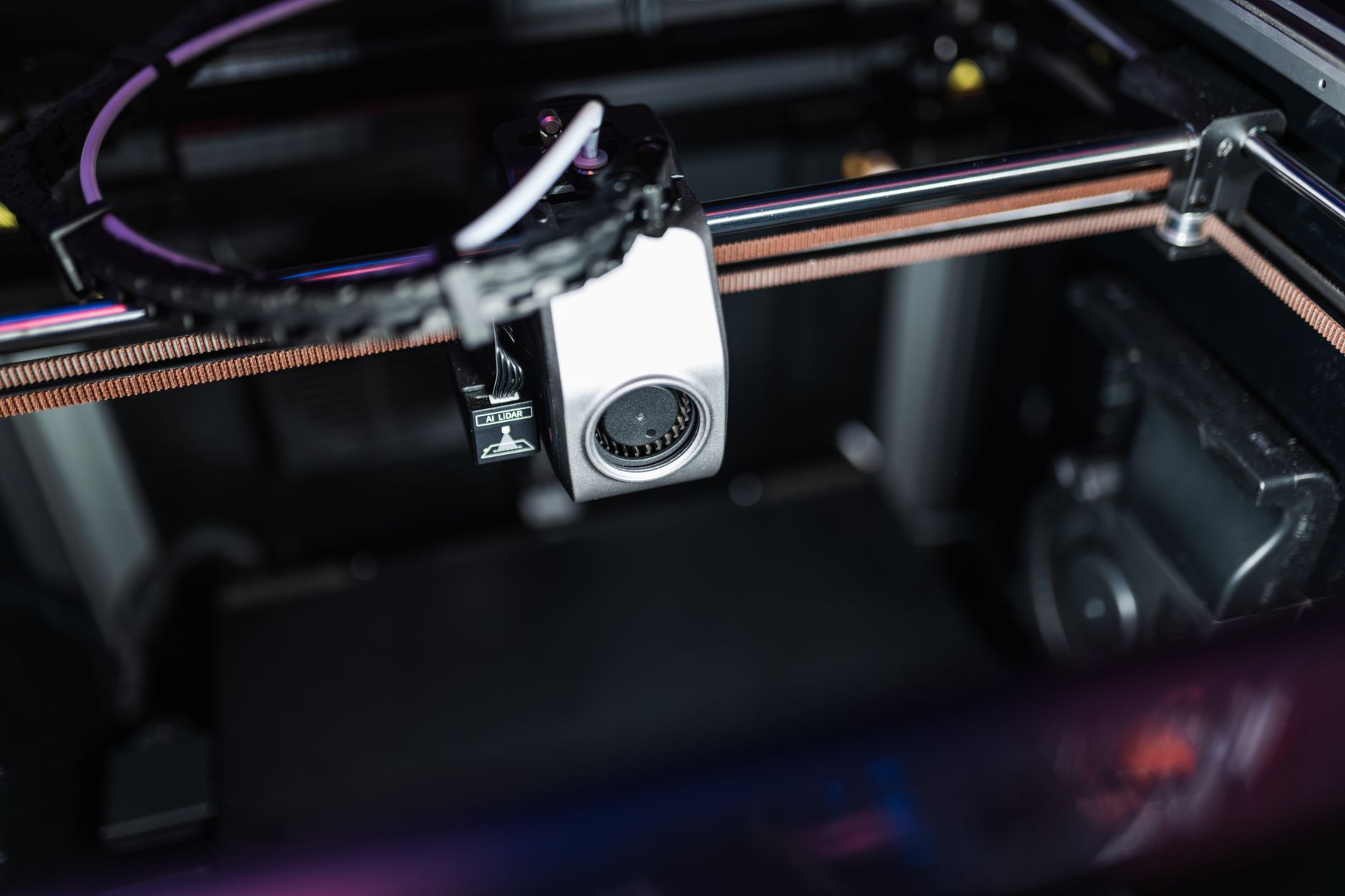 Close-up of a 3D printer nozzle laying down fine layers of filament on a build plate